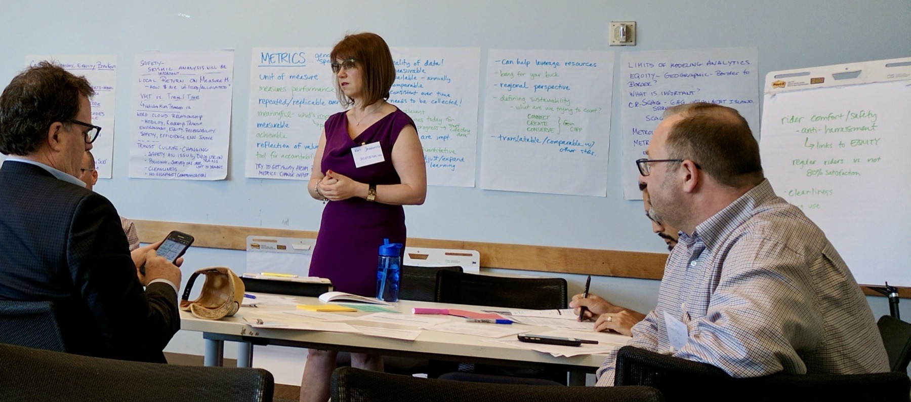 Kat Janowicz speaking at a sustainability workshop at Metro, workshop notes on flip charts behind her
