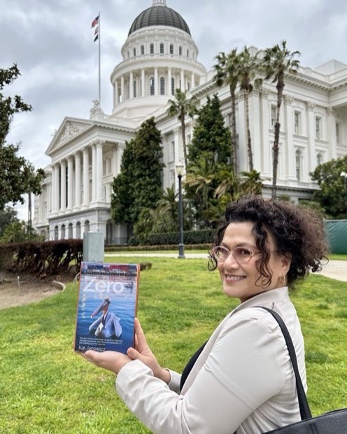 Jamie Newman holding Chasing Zero outside the California State Capitol