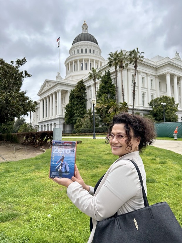 Jamie Newman holding Chasing Zero on the lawn outside the California State Capitol