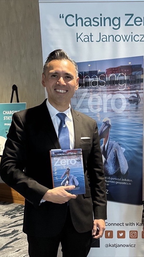 Dr. Noel Hacegaba holding Chasing Zero beside the book banner